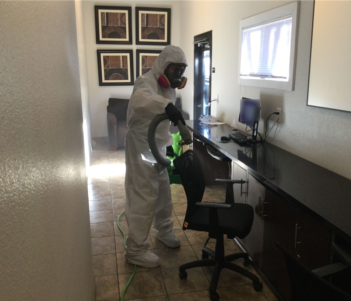 male in white ppe suit cleaning black desk chair, covid cleaning near me, commercial building covid cleaning fair oaks, clean