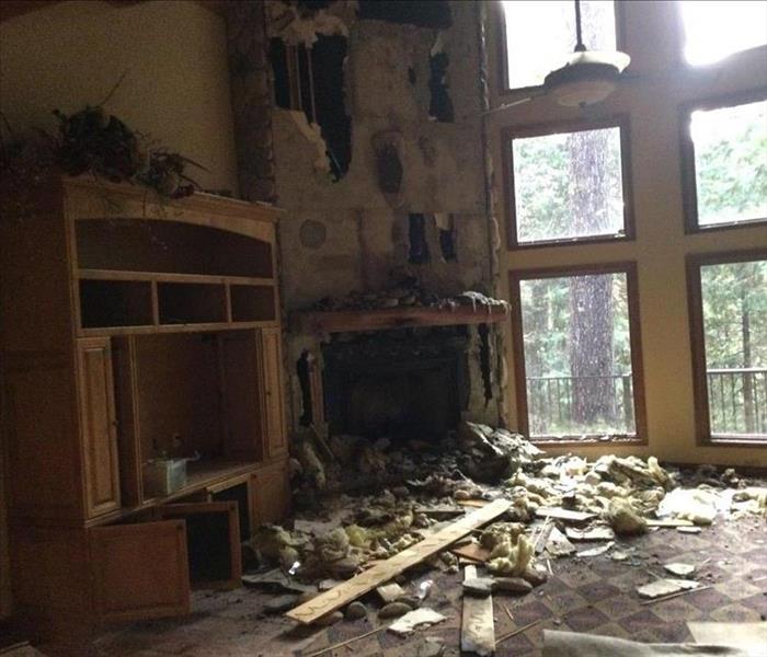 fire place with a wooden cabinet to the left, and window to the right, debris, wood, insulation on the carpet 