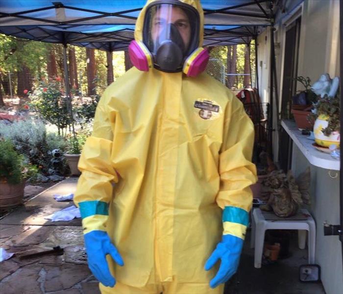 Technician in yellow suit with gloves and respirator